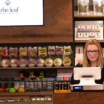 View of dispensary counter with customers and budtender in frame.