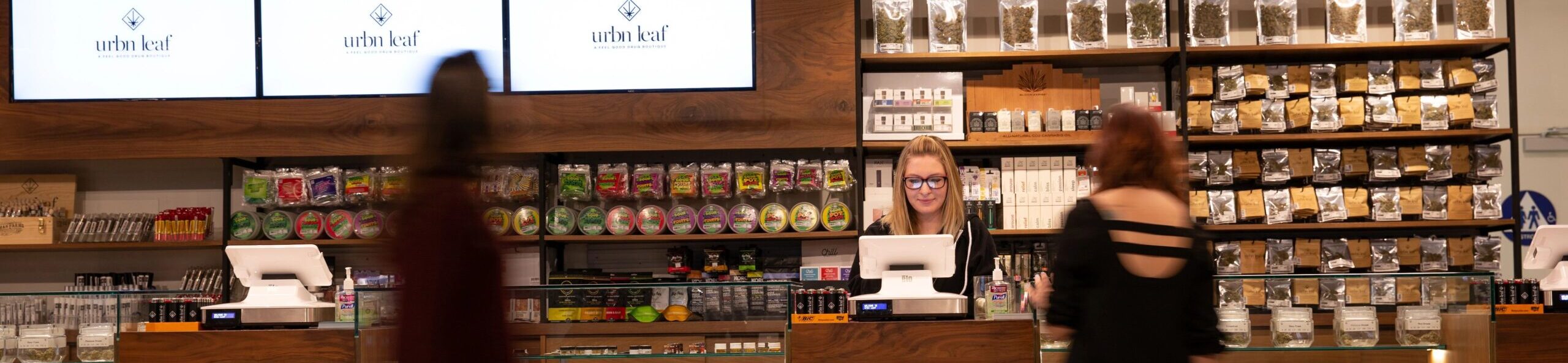 View of dispensary counter with customers and budtender in frame.