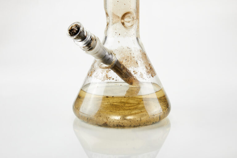Click to see a larger version of the image Chamber of dirty glass bong on white background