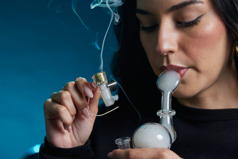 Click to see a larger version of the image Woman smoking cannabis from a bubbler.