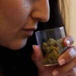 Woman smelling jar of cannabis
