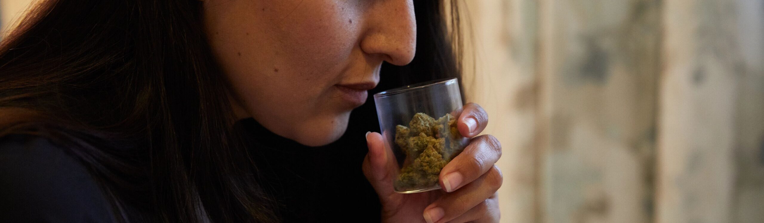 Woman smelling jar of cannabis