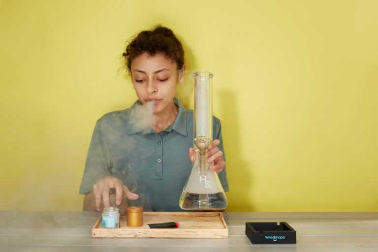 Click to see a larger version of the image Woman exhaling smoke after bong hit.