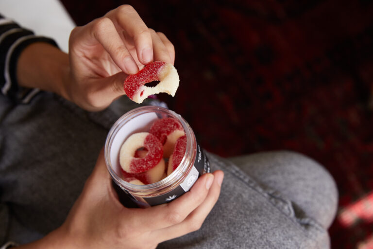 Hands holding edible gummy rings.