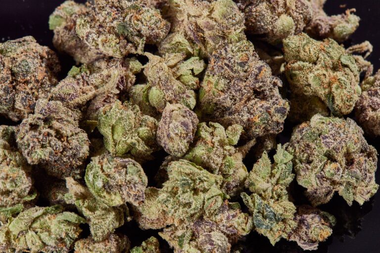 Click to see a larger version of the image Pile of cannabis popcorn buds on black background.