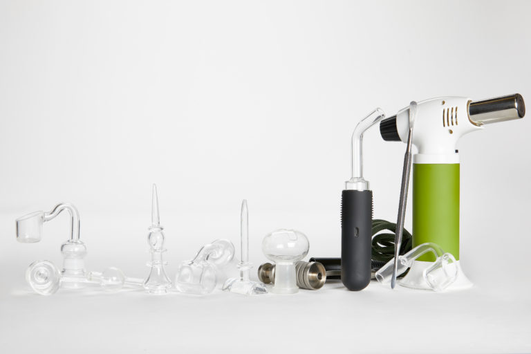 Clear glass dabbing accessories and green blow torch on white background.