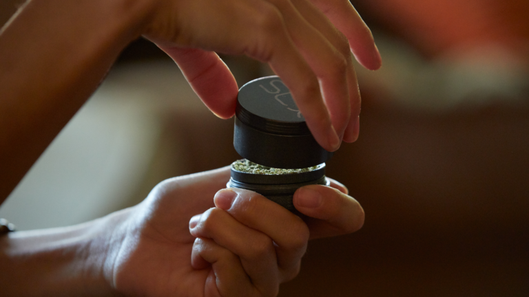 Click to see a larger version of the image grinding weed rolling a blunt