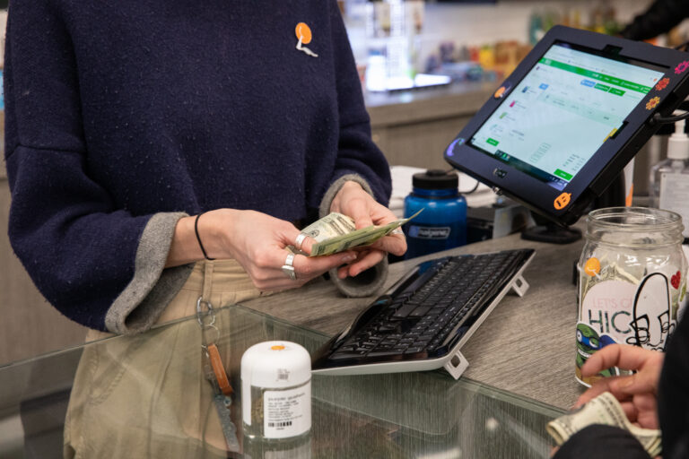 Click to see a larger version of the image Closeup of purchase being made at cannabis dispensary.