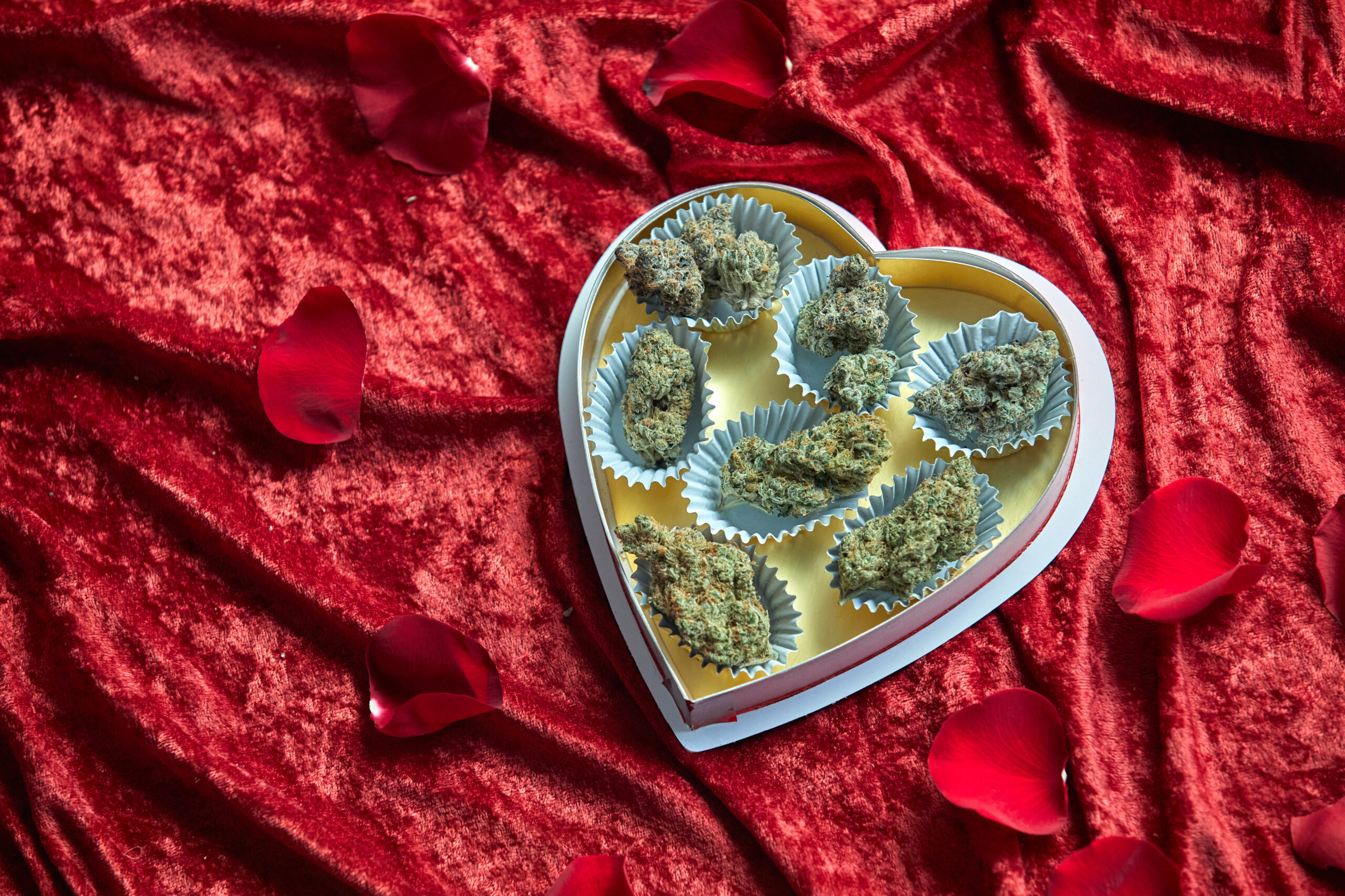 Heart-shaped chocolate box filled with cannabis nugs
