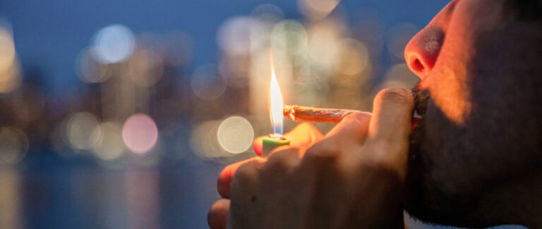 Click to see a larger version of the image man smoking joint in front of city scape