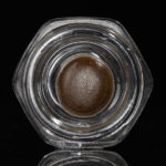 Temple Ball concentrate in hexagonal glass jar on black background