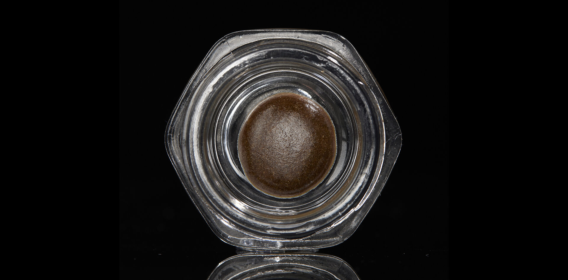 Temple Ball concentrate in hexagonal glass jar on black background