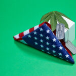 A folded American flag with dog tags and a weed leaf