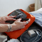 Someone packing a vape pen into a backpack