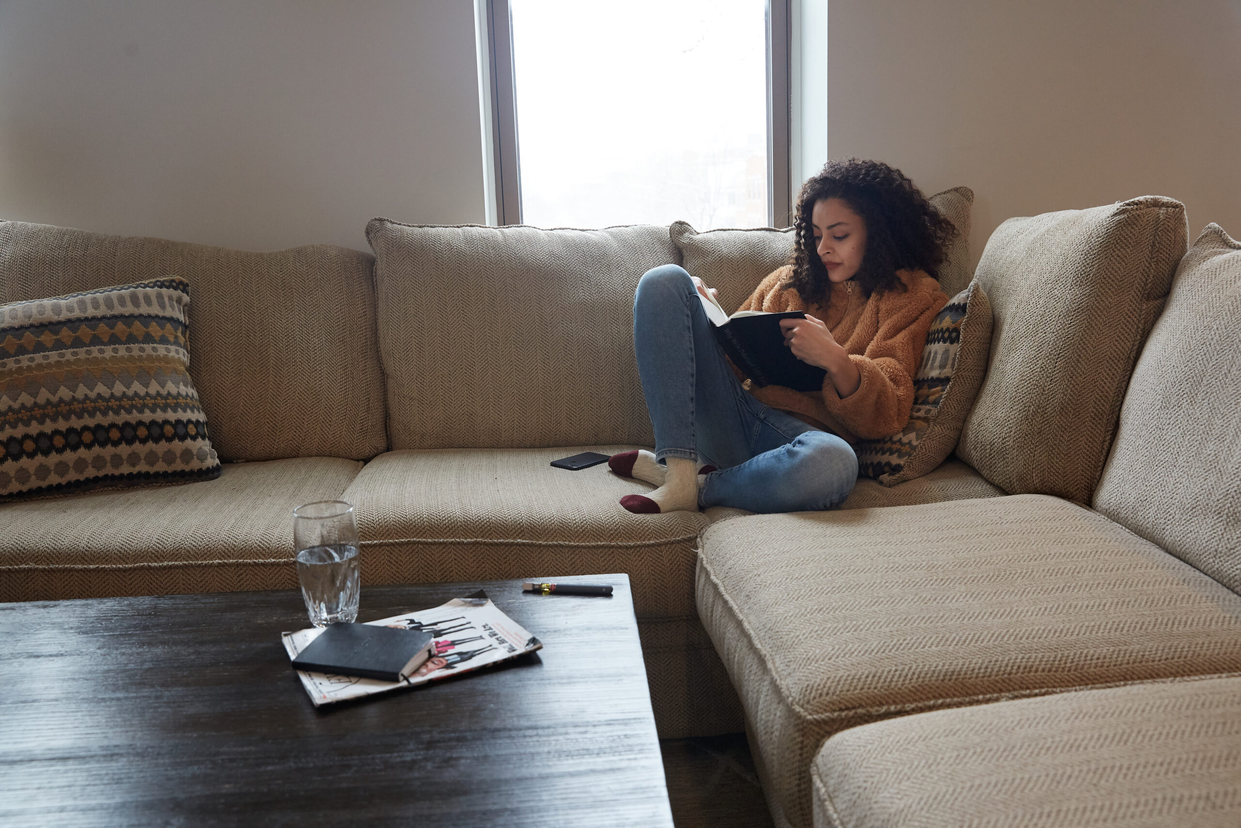 a woman writing in a journal while sitting on a couch