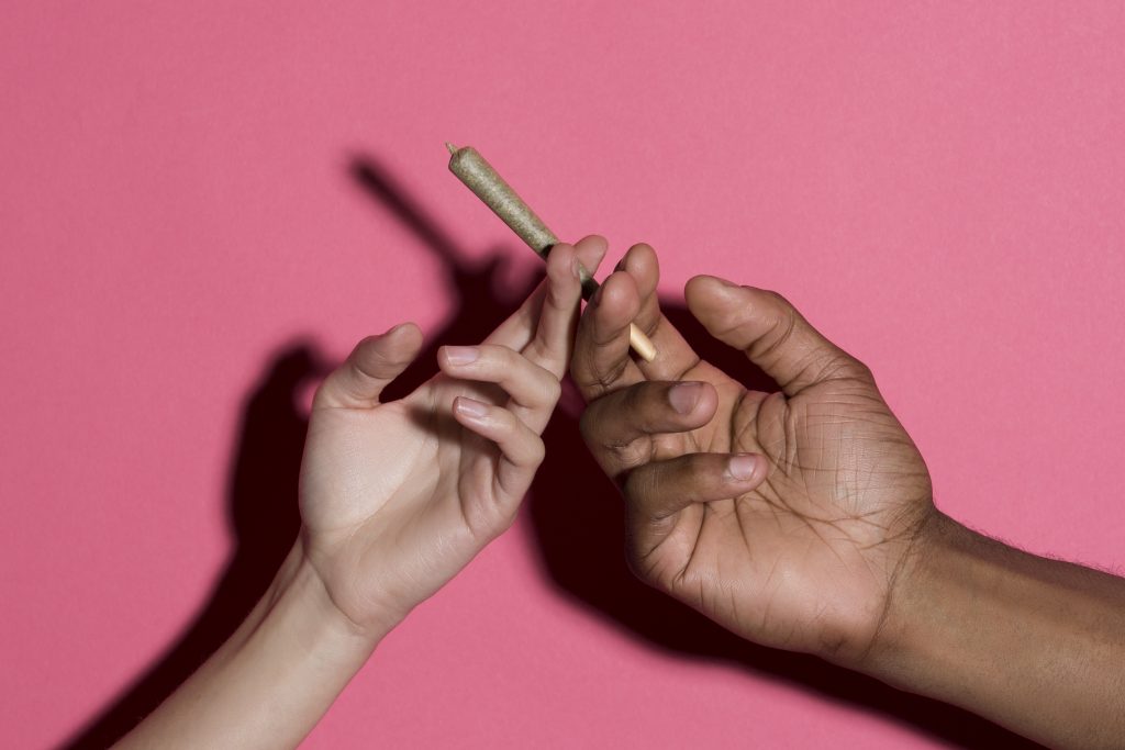 Two hands passing a joint