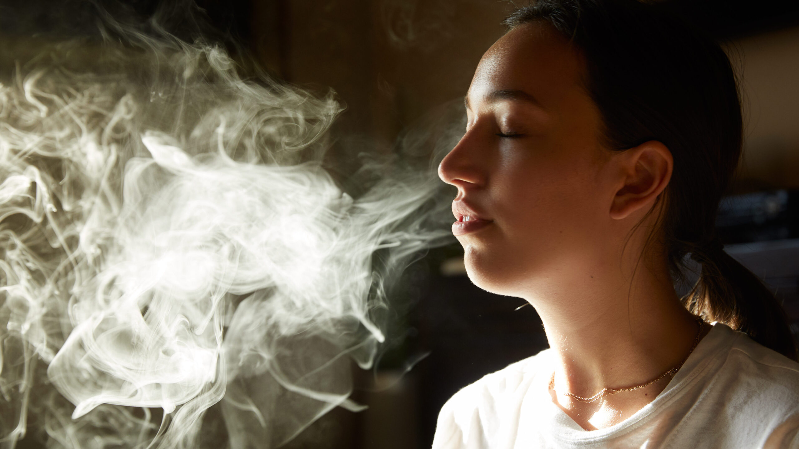 woman exhaling cannabis smoke