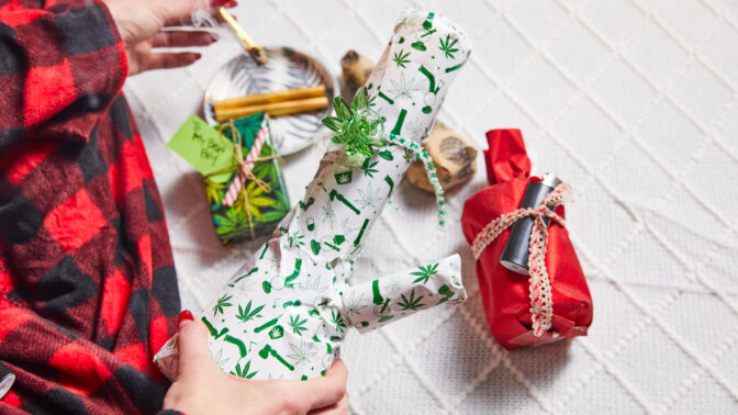 a person holding a bong wrapped in christmas wrapping paper