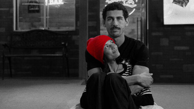 a man and woman embracing while sitting on the ground